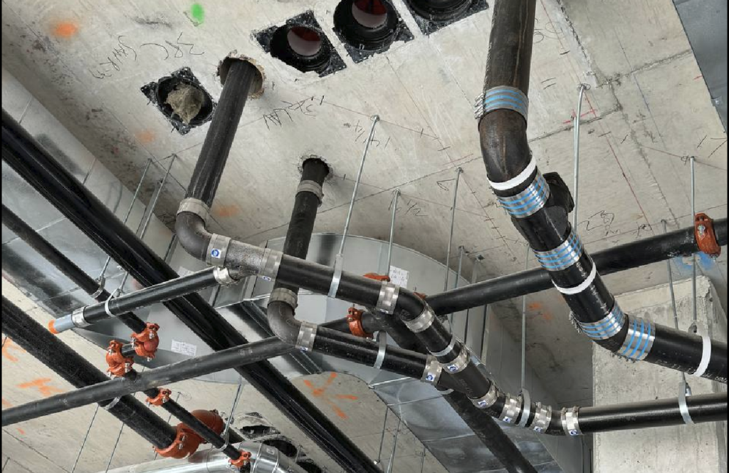 Professional plumbers modifying drainage piping in high-rise commercial building Toronto