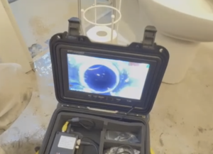Professional plumber performing sewer backup repair and drain camera inspection in commercial building Toronto
