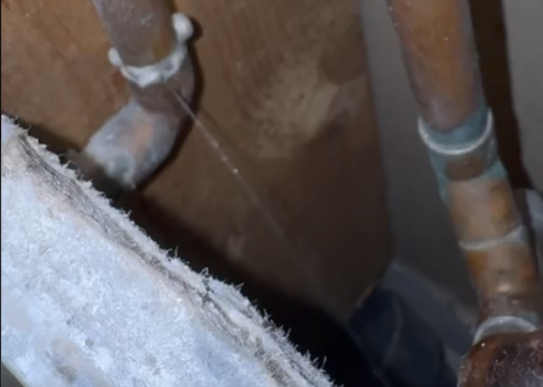 Professional plumber performing water leak detection and repairing cold water copper pipe in residential home Toronto